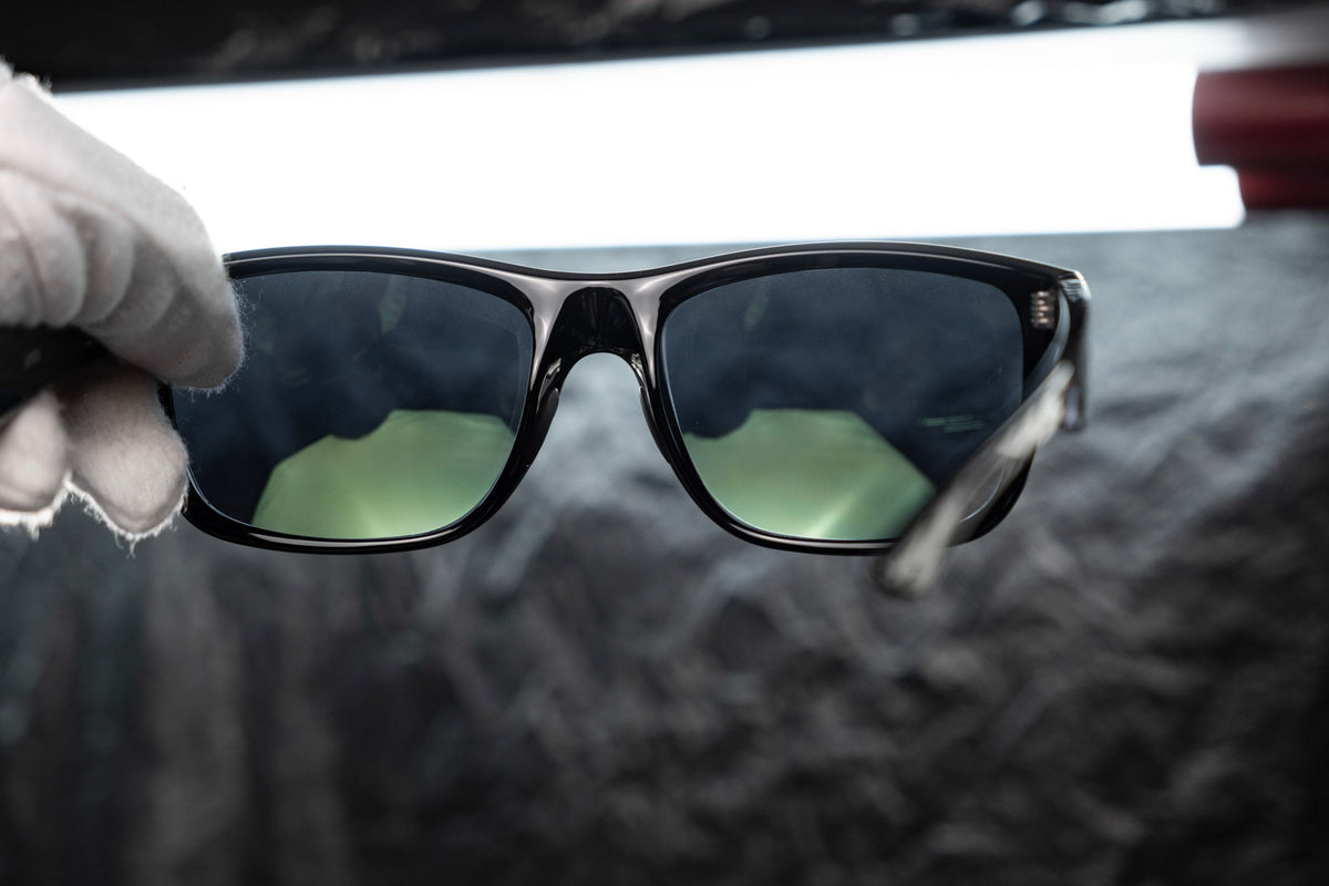 CEVART lens showing its green reverse anti-reflective coating during inspection